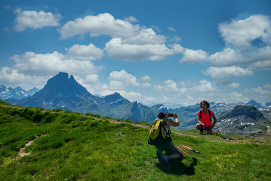 hiking women taking picture of Pic du Midi Ossau in  french Pyrenees mountains