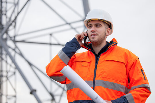 Young engineer or foreman talking  on smart phone on a oil platform or construction site