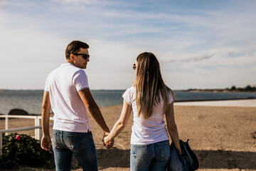 Close up of romantic couple hold hands and walk on the beach
