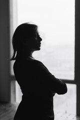 Black and white silhouette of a beautiful young woman at home