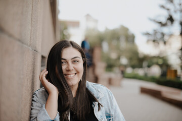 Fototapeta premium Portrait of a beautiful young woman with natural light outdoors in the city