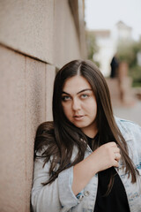Fototapeta premium Portrait of a beautiful young woman with natural light outdoors in the city