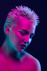 Lovely. Portrait of female fashion model in neon light on dark studio background. Beautiful caucasian woman with trendy make-up and well-kept skin. Vivid style, beauty concept. Close up. Copyspace