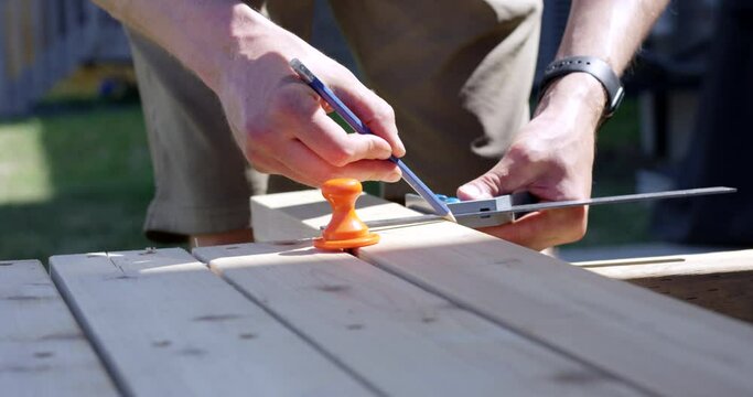 Man marking piece of wood with pencil - close up