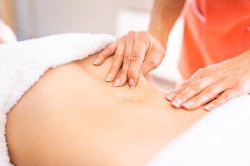 Obraz na płótnie Canvas Woman have belly massage in light procedure room. Anti-cellulite massage, diastasis