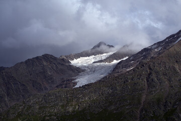 Peaks of mountains with glaciers.
View of the two peaks Bolshoy Kogutai and Maly Kogutai from the slope of Mount Cheget. Terskol, Caucasus, Russia.
