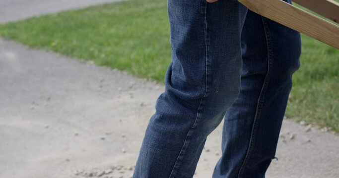 Man picks up wheelbarrow - close up on handles