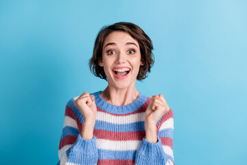 Photo of charming cute lady raise arms excited open mouth wear colorful striped pullover isolated...