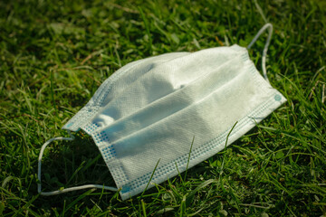 Medical face mask in the grass. Social distancing to prevent spread of COVID-19 coronavirus in the New Normal.