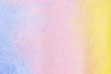 Aquarelle paper canvas painted into pink, blue and yellow colors