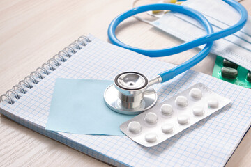 medicines, pills, medical stethoscope and notepad for notes on the table, disease diagnosis concept