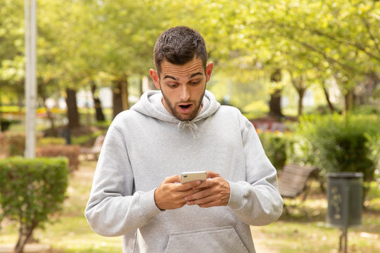 Attractive Man Surprised With Mobile Phone Outdoors