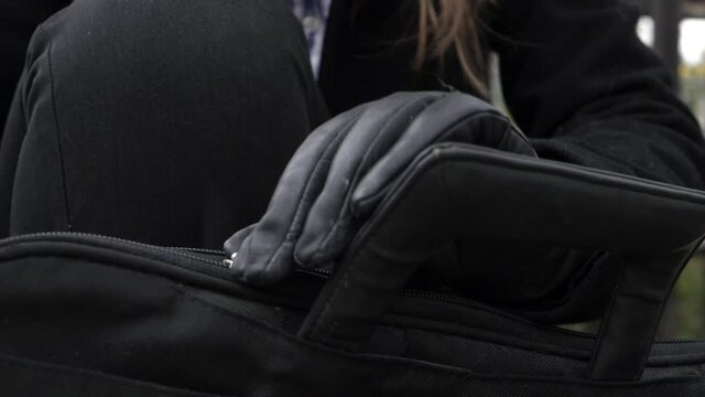Business woman zipping briefcase and gloves close up shot