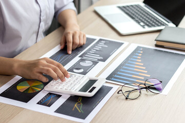 Business woman are working on calculating statistics from graphs of company performance reports. To develop and fix the business system.