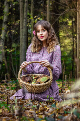 Girl in the forest in a dress with a floral pattern with a basket full of mushrooms. Photo in retro style.