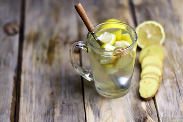 Hot ginger-lemon drink in a mug. on a wooden surface. Folk remedies for colds. Antiviral products. Selective focus. Macro.