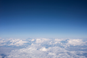 Fototapeta na wymiar View from a window of plane with a blue cloudy sky background