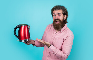 he like this. electric home device. bearded man use red electric kettle. male housekeeping concept....