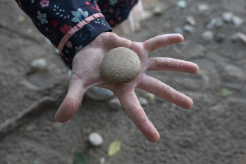 child hand with stone from river