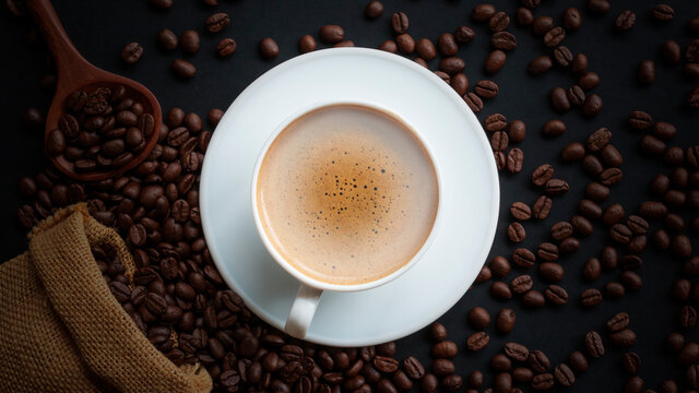 Hot espresso coffee cup and coffee bean in a sack on vintage table, top view. © chiew