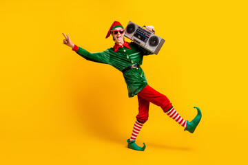 Full length body size view of his he nice attractive crazy cheerful cheery funny guy elf carrying tape player having fun dancing isolated over bright vivid shine vibrant yellow color background - obrazy, fototapety, plakaty