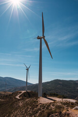 Paisaje de turbinas e&oacute;licas rodeado de monta&ntilde;as