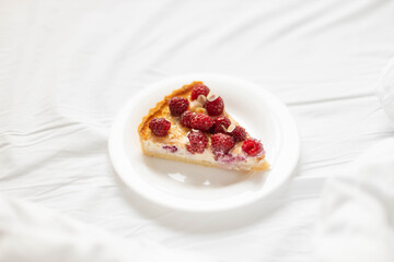 Raspberry piece of cheesecake on the bed