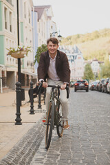 Vertical shot of happy mature businessman riding bicycle to work