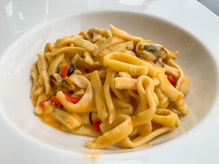 Scialatielli ai frutti di mare con vongole e cozze fotografati in un piatto bianco