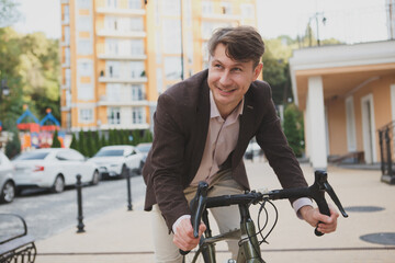 Excited mature man laughing, cycling in the city