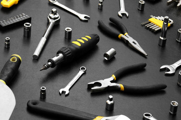 Many different tools for repair work on a black background.