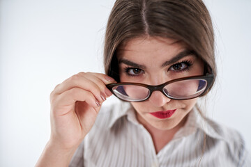Mistrustful businesswoman looking over spectacles