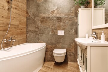 bathroom with built-in toilet system, white corner bathtub, mirror and cupboards, sink and steel...