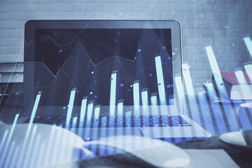 Stock market graph and table with computer background. Double exposure. Concept of financial analysis.