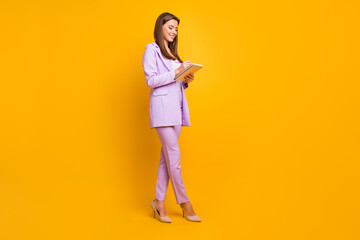 Fototapeta na wymiar Full length photo of pretty business lady holding diary writing corporate notes for boss reliable assistant conference wear purple office suit isolated yellow color background