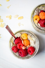 Chia pudding with berries in glass jar, white background. Healthy food concept.