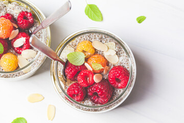 Chia pudding with berries in glass jar, white background. Healthy food concept.