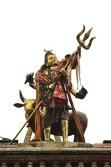 Metal statue of hinduism deity of Lord Shiva, with his characteristic trident,  on the top of...