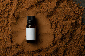 Top view of pile of cococa powder and glass bottle of coca oil.Empty space