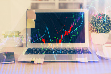 Financial graph colorful drawing and table with computer on background. Multi exposure. Concept of international markets.