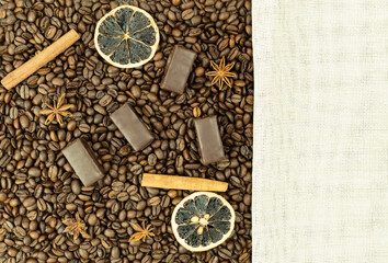 Fototapeta na wymiar Delicious chocolates and cinnamon on coffee beans