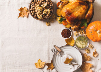 Fall thanksgiving table with roasting chicken or turkey, nuts, pie, pumkins and other food on light