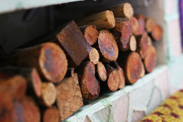 stacked brown firewood in a small pile on a stone surface