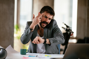 Young businessman working on projects. Angry businessman  talking to the phone..