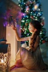a girl in a light dress checks the Christmas sock