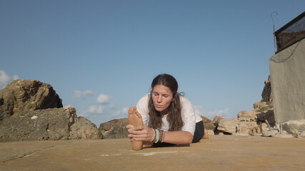 Young woman practising yoga, split position holding her feet. . High quality photo