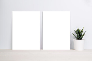 Blank paper sheet copy space with mockup and plants in potted on wooden table, poster and invitation with empty on desk, card decoration your design or branding, simplicity and minimal, nobody.