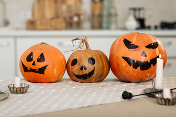 Halloween pumpkin head jack lantern with burning candles. illuminated halloween pumpkins with candles in the kitchen.