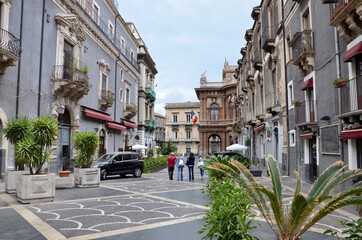 Traditional historic houses in the old town of Catania in Sicily, a group of people is walking...