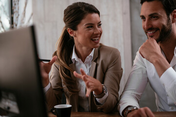Businessman and businesswoman in office. Two friends drinking coffee while working on the project..